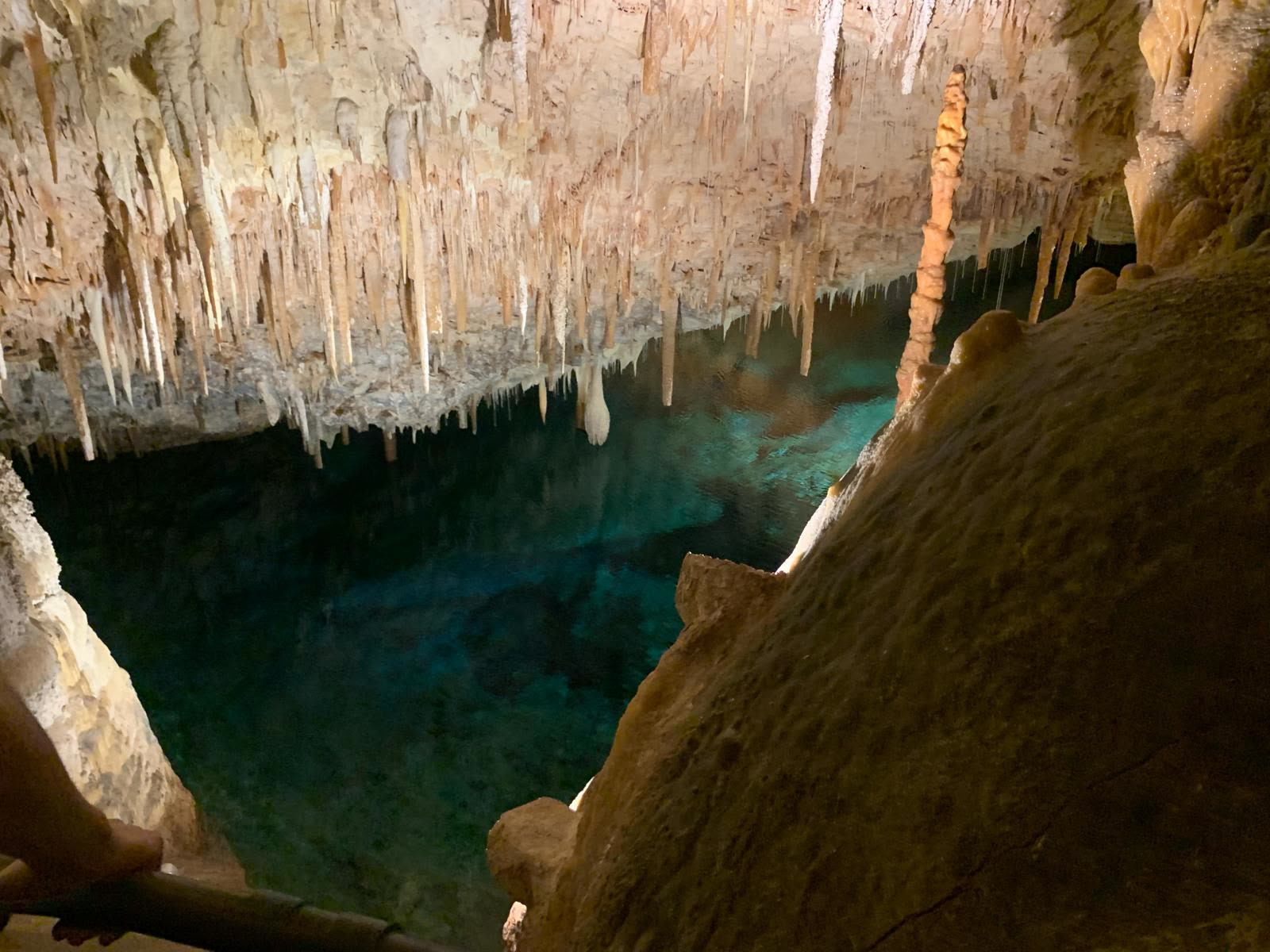 Cave with a turquoise pool and stalactites
